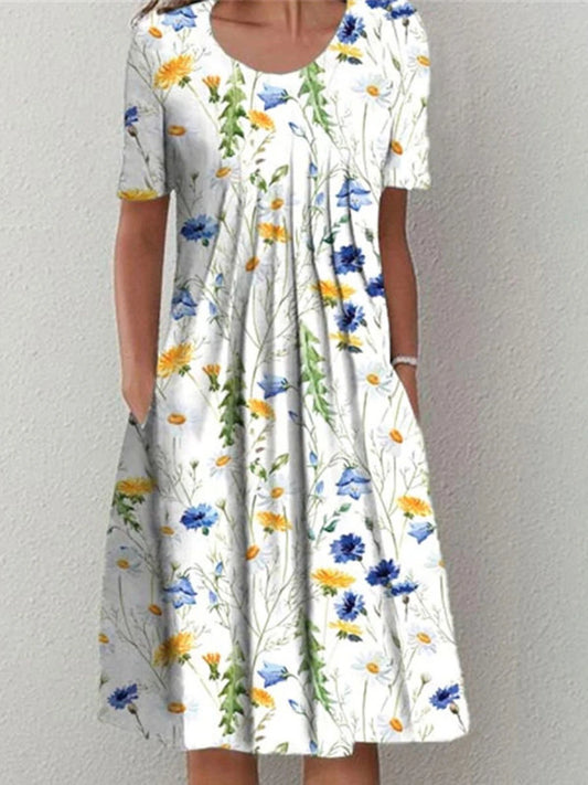 Woman wearing an icevoolen white midi dress with blue and yellow wildflower prints and short sleeves.