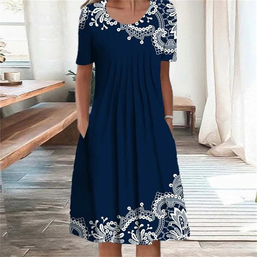Elegant navy blue loose midi dress with white decorative embroidery-style prints and side pockets.