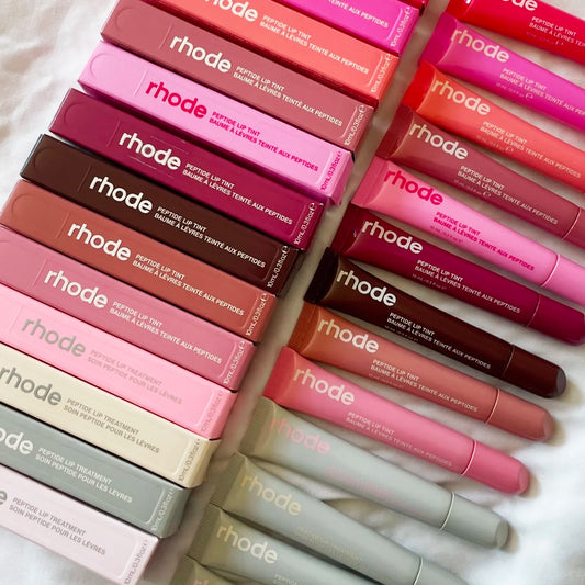 Close up of Rhode peptide lip treatment tubes and packaging showing different shades and colors.