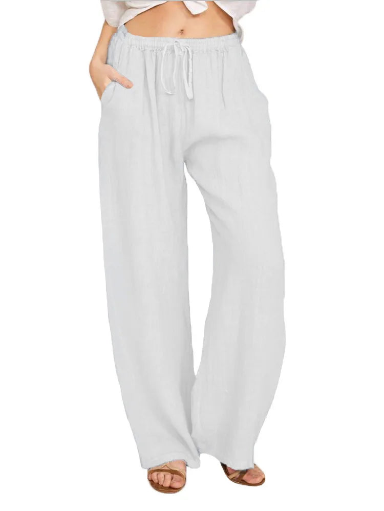Woman wearing loose white linen-blend wide leg casual pants with drawstring waist on a white background.
